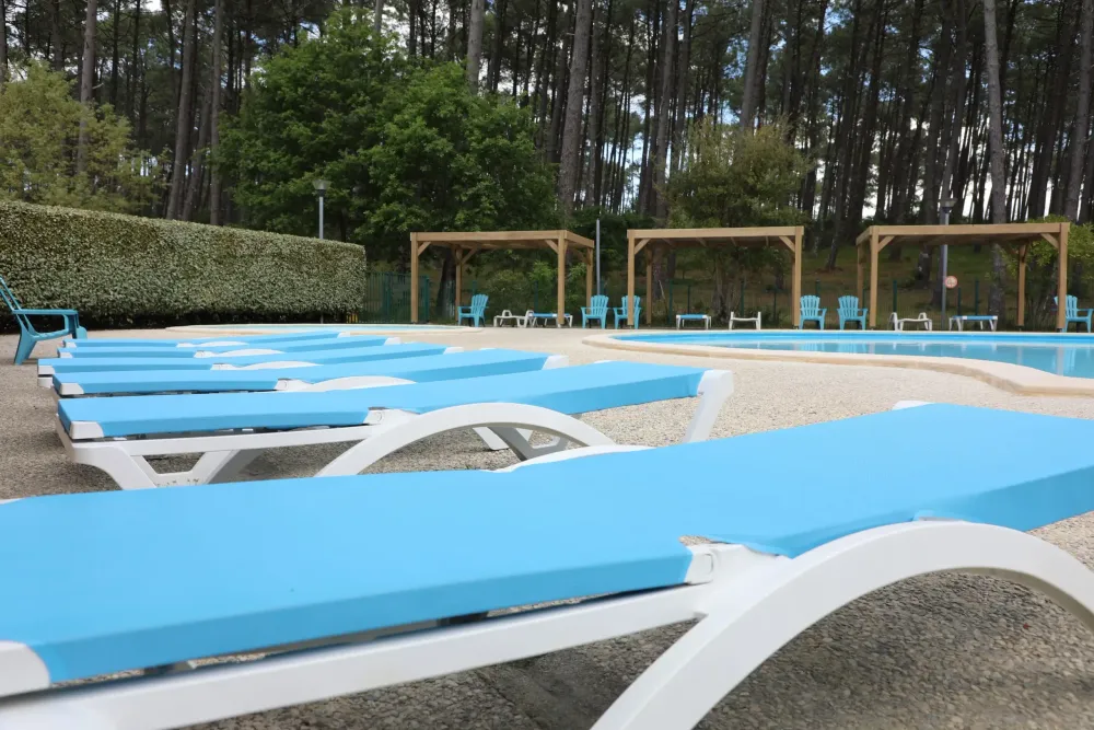 Transats bleus au bord de la piscine
